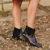 Bota corta negra de cuero con elástico lateral, caña de 12 cm y taco de madera de 4 cm.