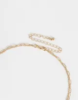 Collar corto doble, uno con cadena dorada con dijes de bota cowboy, rosa, corazón y herradura, y otro con perlas.
