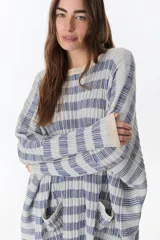 Sweater de punto con diseño a cuadros en tonos celeste, azul y beige.