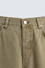 Pantalón de jean color verde oliva, corte balloon fit, con cinco bolsillos, efecto lavado y costuras giradas hacia adelante.