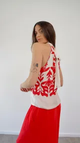 Top de seda estampado en blanco y rojo, con cuello halter y lazo en la espalda.