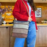 Bandolera de símil cuero con paneles combinados en tonos marrón claro, verde y marrón oscuro. Cuenta con apertura superior con cierre, amplio bolsillo frontal con cierre, tres bolsillos internos (dos con cierre) y un bolsillo trasero con cierre. Incluye correa larga regulable.