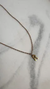 Collar dorado con cadena de eslabones finos y dije con la letra R.