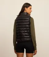 Chaleco puffer deportivo negro confeccionado en poliamida, con cuello alto y cierre frontal con cremallera. Incluye bolsita para guardarlo.