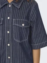 Vestido camisero midi de denim azul con rayas verticales blancas, cuello camisero, mangas 3/4, cierre frontal con botones y dos bolsillos de parche en el pecho.