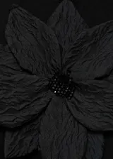 Top negro de punto fino con tirantes finos y maxi flor en el frente.