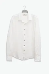 Camisa blanca de manga larga confeccionada en lino 100%, con calce recto y relajado. Presenta frente abotonado con botones de coco con logo y parche con logo de la marca.