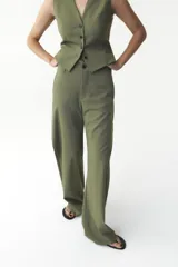 Pantalón de tiro alto color verde oliva, de corte recto y pierna ancha, con bolsillos laterales y traseros. Cierre frontal con cremallera y botón.