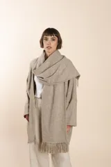 Saco de lana color marrón claro, con mangas amplias, cuello tipo bufanda con flecos y bolsillos laterales. Diseño oversize sin forro.