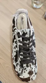 Zapatillas urbanas con estampado animal print en blanco y negro, detalles en gamuza negra y cordones negros. Incluye cordones crudos extra.