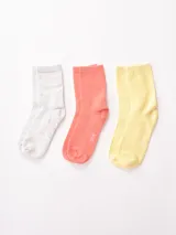 Pack de tres pares de medias de caña media, una gris jaspeado, una color salmón y una amarilla.