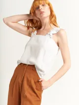Pantalón de lino de tiro alto, con pierna recta y diseño de pinzas en el delantero, cierre frontal y bolsillos laterales.