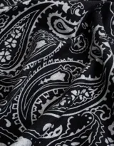 Pañuelo cuadrado negro con estampado paisley en blanco y borde con diseño geométrico.