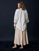 Camisa color crudo con bordado tipo broderie, cuello con solapa, manga tres cuartos y cierre frontal con botones.