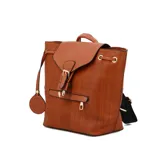 Mochila color beige con estampado a cuadros y detalles en marrón. Tiene una solapa con cierre de hebilla, un bolsillo frontal con cierre y un dije colgante con forma de cara sonriente.