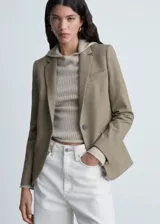 Blazer color beige con estampado de micro pata de gallo, cuello con solapa, cierre frontal con botón, forro interior, abertura en la parte posterior y bolsillos de ribete con solapa. Diseño entallado y mangas largas abotonadas.