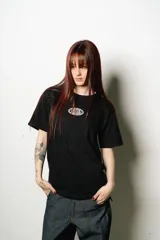 Remera negra de corte regular fit, con un pequeño parche ovalado estampado en el pecho y un gran logo de estilo manuscrito en la espalda.