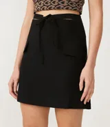 Minifalda negra de corte recto, con cintura alta y lazo ajustable. Presenta bolsillos laterales con solapa y cierre trasero con cremallera.