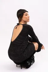 Vestido corto negro tejido con lurex, escote redondo y mangas largas.