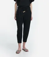 Pantalón jogger color naranja, de tiro medio, con cintura elástica, lazo ajustable y pliegues delanteros.