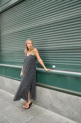 Vestido largo negro con estampado de lunares blancos, breteles finos y escote en V.