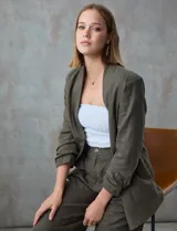 Blazer blanco de lino con cuello con solapa, bolsillos sastre y mangas fruncidas.
