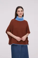 Poncho holgado de algodón, con cuello tipo polera y combinaciones de color marrón y azul.