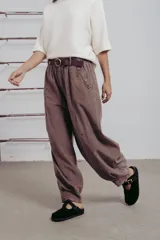 Pantalón de corte amplio color marrón, con cintura elastizada, detalle de botones en los laterales y cinturón incluido.