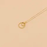 Gargantilla de oro amarillo 9k con dije de dos aros entrelazados, uno de ellos con incrustaciones de circonias.