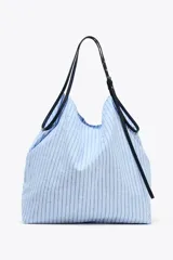 Bolso tipo shopper en tejido con rayas celestes y grises. Asa a contraste de color negro y material sintético con detalles metálicos.