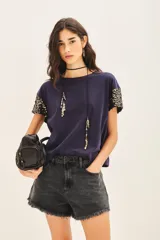 Remera azul marino de algodón con cuello redondo y mangas cortas con apliques de lentejuelas doradas.