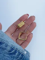Par de aros dorados, uno con forma cuadrada y otro con diseño labrado.