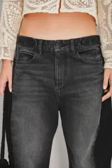 Jean de corte barrel con diseño de pierna curva y holgada, confeccionado en denim negro con efecto lavado. Presenta un estilo moderno y estructurado con costuras laterales marcadas.