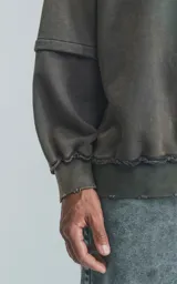 Buzo cuello redondo color gris oscuro con efecto gastado, costuras expuestas, calce oversize y roturas.