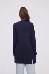 Saco negro de tejido suave, con corte al cuerpo y manga larga.