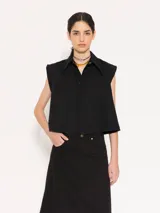 Camisa negra corta sin mangas, de corte recto y cuello clásico.