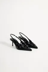 Zapato destalonado de cuero negro con punta fina, tacón fino y detalle de ojales metálicos.
