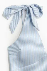 Traje de baño enterizo a rayas verticales celestes y blancas, con escote en V y breteles con lazos ajustables.