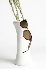 Lentes de sol estilo ojo de gato, montura negra brillante y lentes oscuros polarizados.