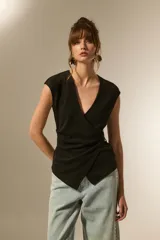 Top negro de manga corta, escote en V pronunciado, con diseño cruzado tipo wrap y ajuste lateral con apliques dorados.