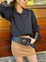 Camisa negra con mangas abullonadas, puños de encaje y cuello clásico.