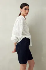 Bermuda de jean azul de corte clásico y largo a la rodilla.