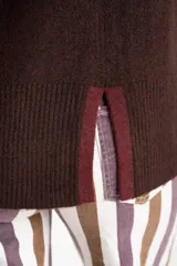 Sweater negro de tejido grueso con cuello alto acanalado. Presenta una franja decorativa en las mangas y el cuello en hilo marrón con brillo (lurex).