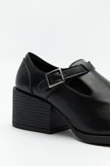 Zapato negro con diseño tipo T-bar, tira con hebilla lateral y taco ancho de 6cm.