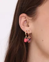 Set de tres pares de aros tipo argolla dorados con dijes colgantes de frutas de color rosa.