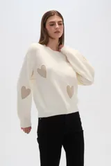 Sweater color crema de tejido de punto con apliques de corazones en color beige.