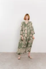 Vestido largo azul con estampado floral en tonos beige, confeccionado en viscosa. Presenta escote en V, botonadura completa en el frente y mangas largas con volados.