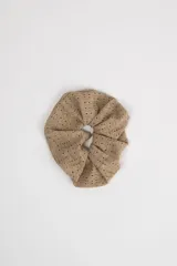 Scrunchie beige con textura perforada.