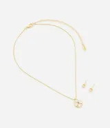 Conjunto de collar y aros dorados con colgante y dije de trébol de cuatro hojas con incrustaciones de circonitas blancas. Los aros son tipo botón con cierre a rosca.