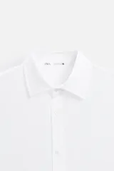 Camisa celeste de lino, de corte recto, manga larga y cuello clásico.